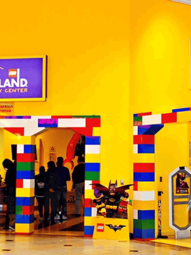 Colorful LEGO-themed entrance at Legoland Discovery Center, vibrant yellow walls and playful decor.