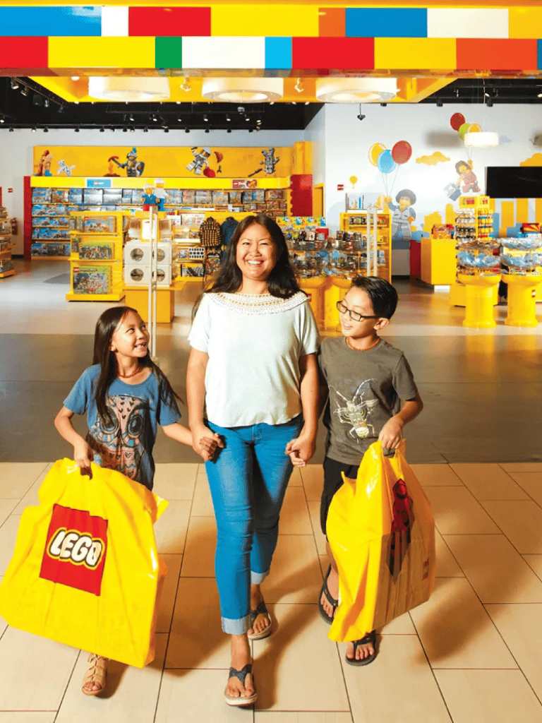 Vibrant toy store shopping experience with kids holding LEGO bags, colorful shelves, playful animation murals.