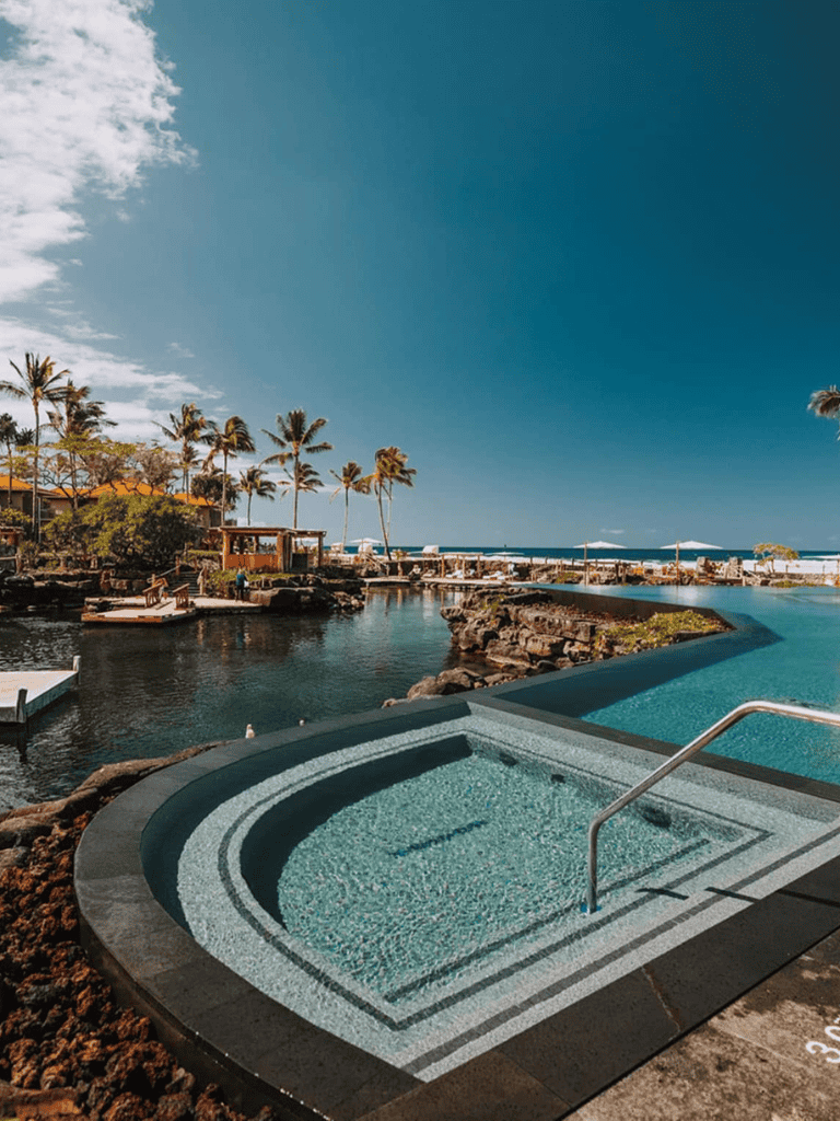Luxurious oceanfront hot tub with panoramic island views, tropical palms, and resort amenities at QuestForDirections.