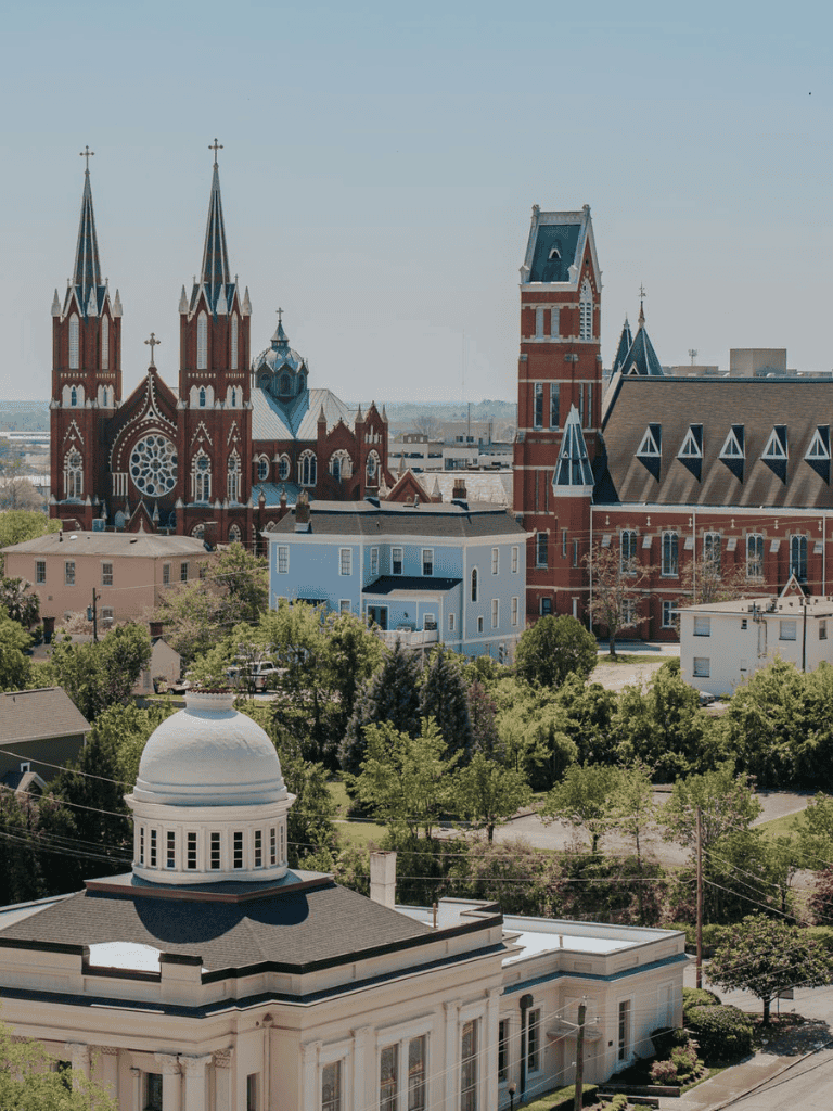 Historic church with tall steeples and colorful architecture in downtown cityscape.