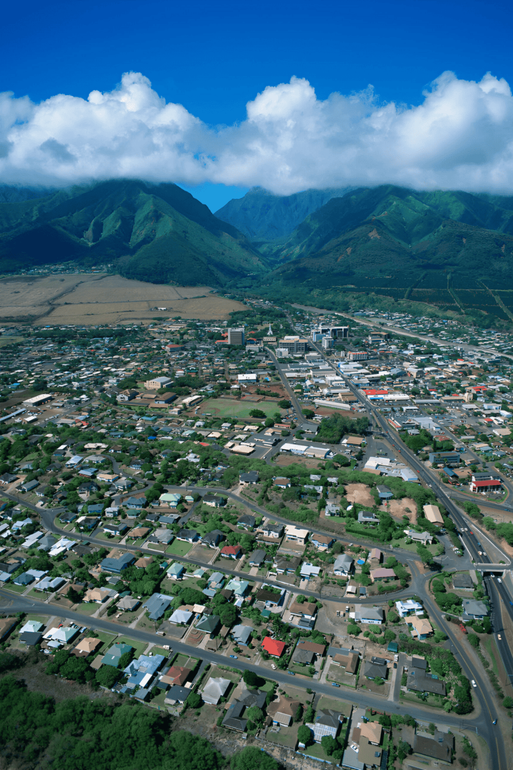 Aerial view of a town nestled in lush green mountains with a vibrant community and scenic landscape.