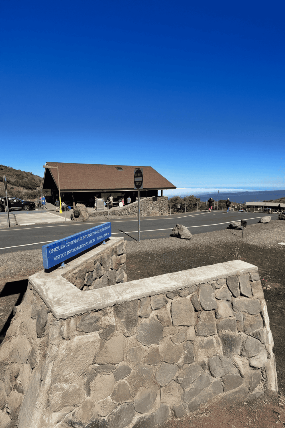 Onizuka Center for International Astronomy Visitor Information Station, elevated viewing area, clear blue sky, scenic mountain landscape.