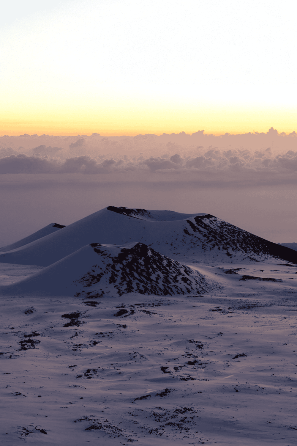 Snow-covered mountain peaks during sunrise, scenic winter landscape for adventure travel.