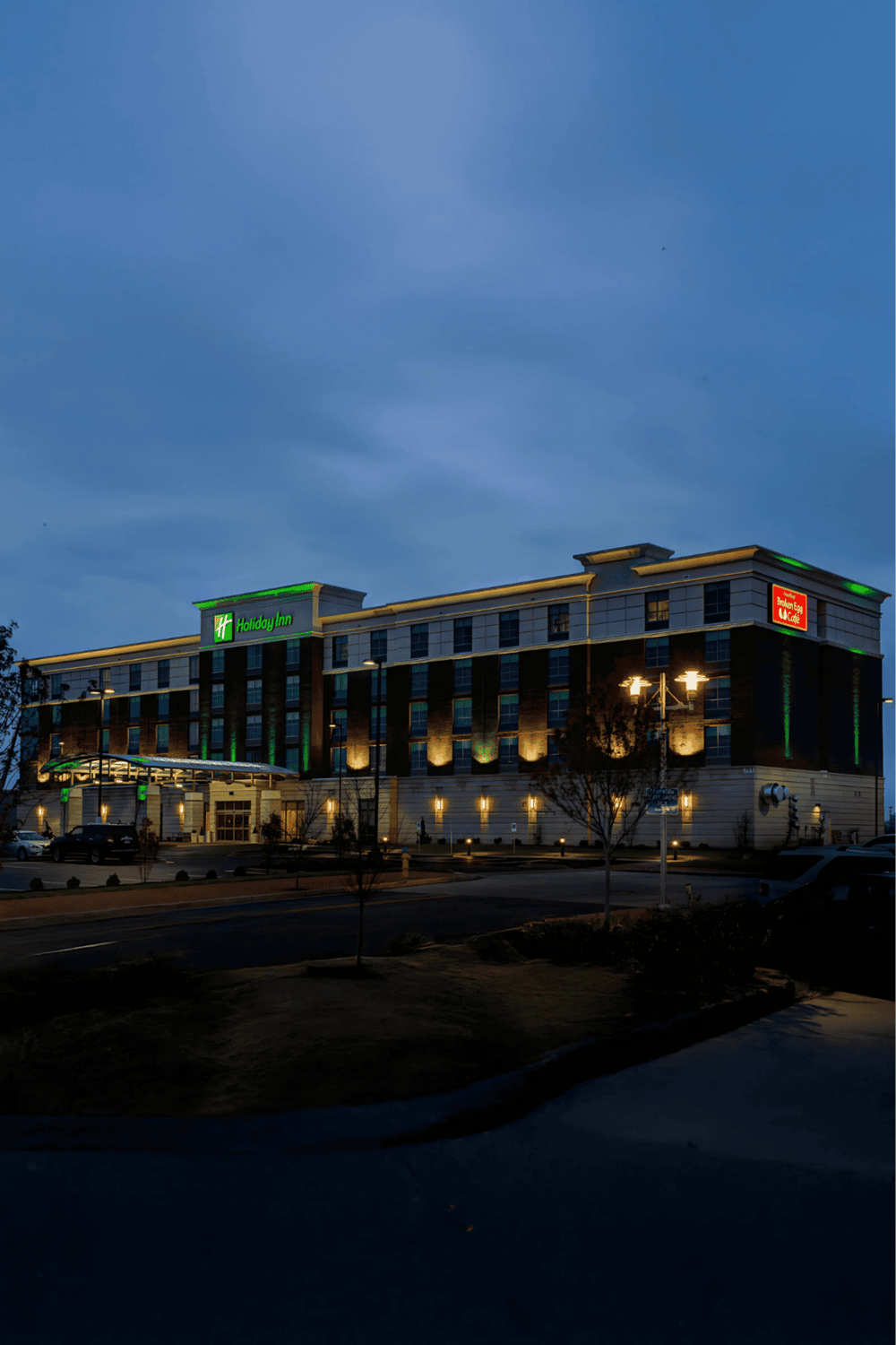 Convenient Holiday Inn hotel with modern amenities, illuminated at dusk, perfect for business or leisure stays.