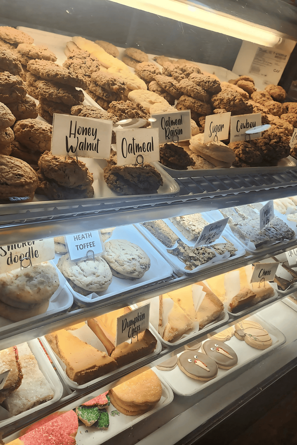 Delicious homemade cookies in a bakery display case with various flavors and labels.