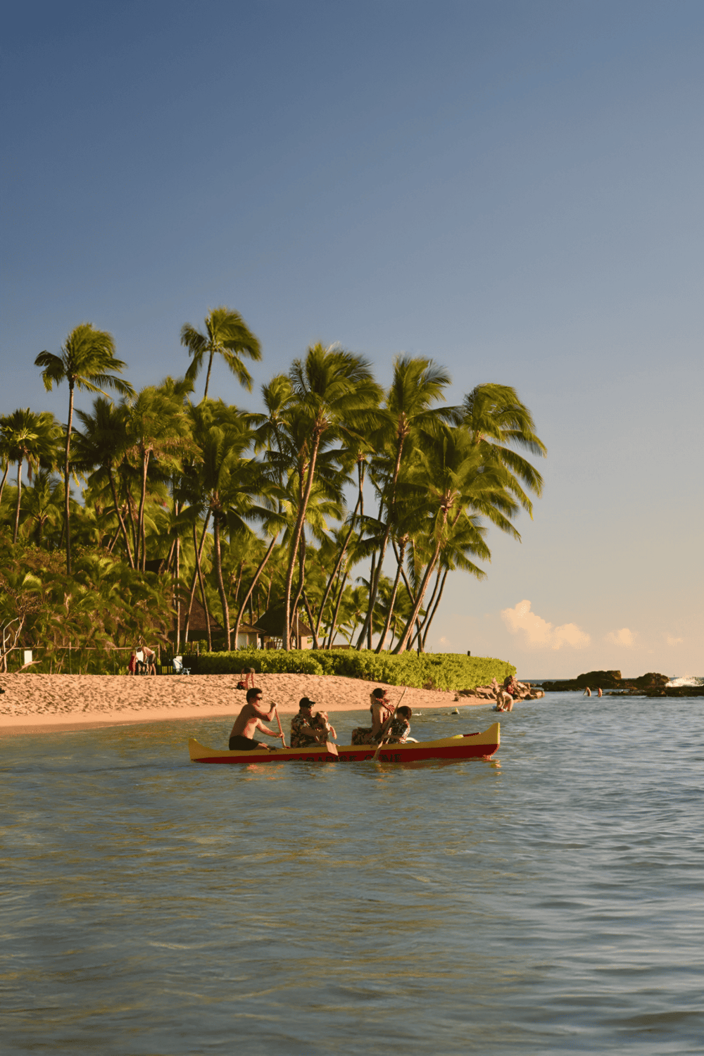 Bright tropical beach with palm trees and people paddling in a canoe for travel and adventure.