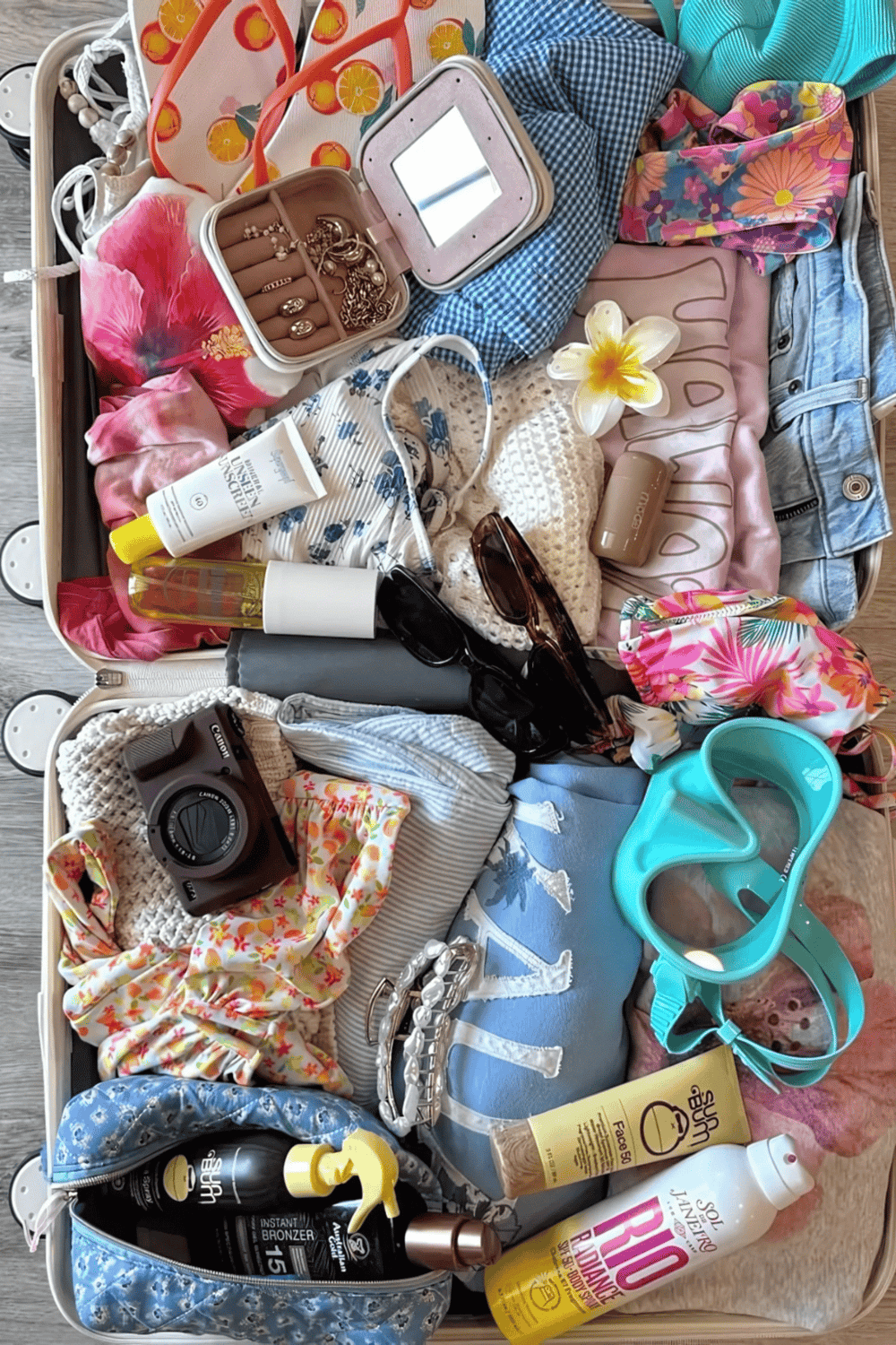 Towel, toiletries, jewelry, sunglasses, sunscreen, camera, swimwear, and accessories for travel or beach trips.