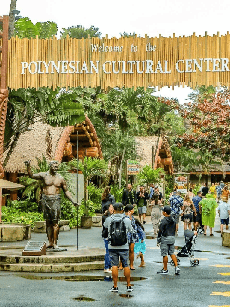 Vibrant Polynesian Cultural Center entrance with tropical landscaping and visitors exploring.