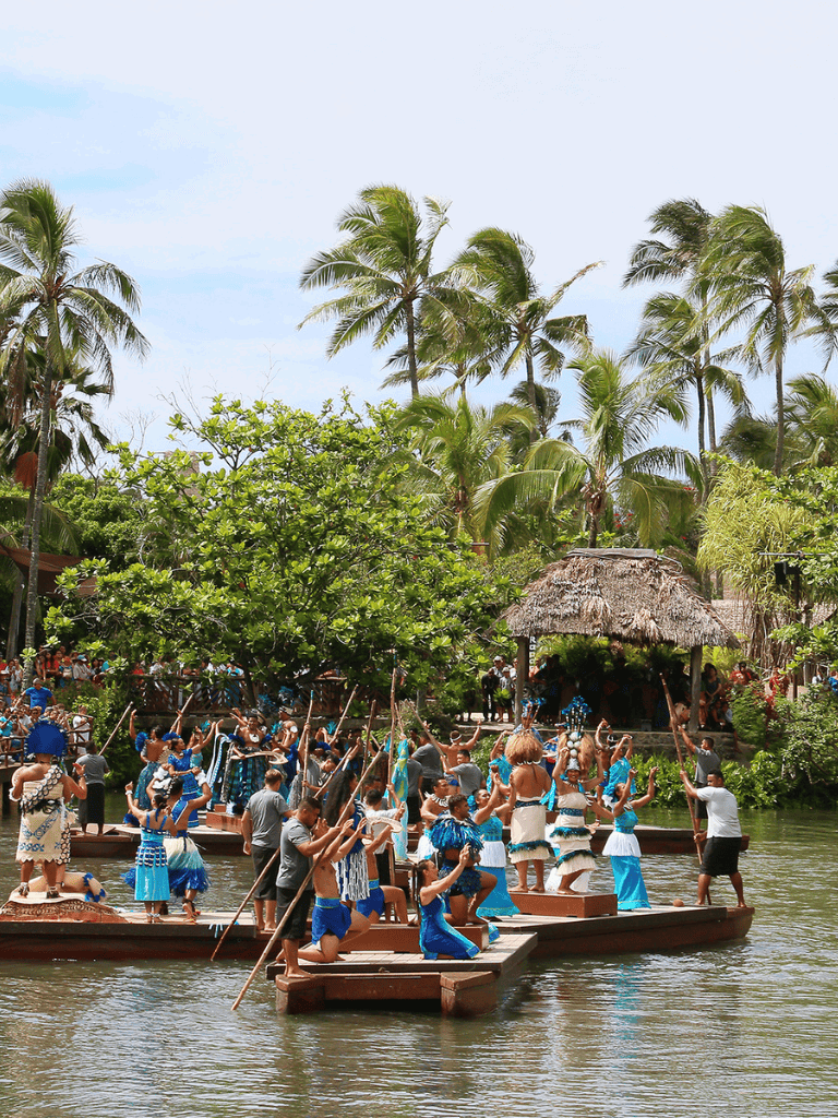 Vibrant traditional Polynesian dance on floating platforms at QuestForDirections tropical destination.