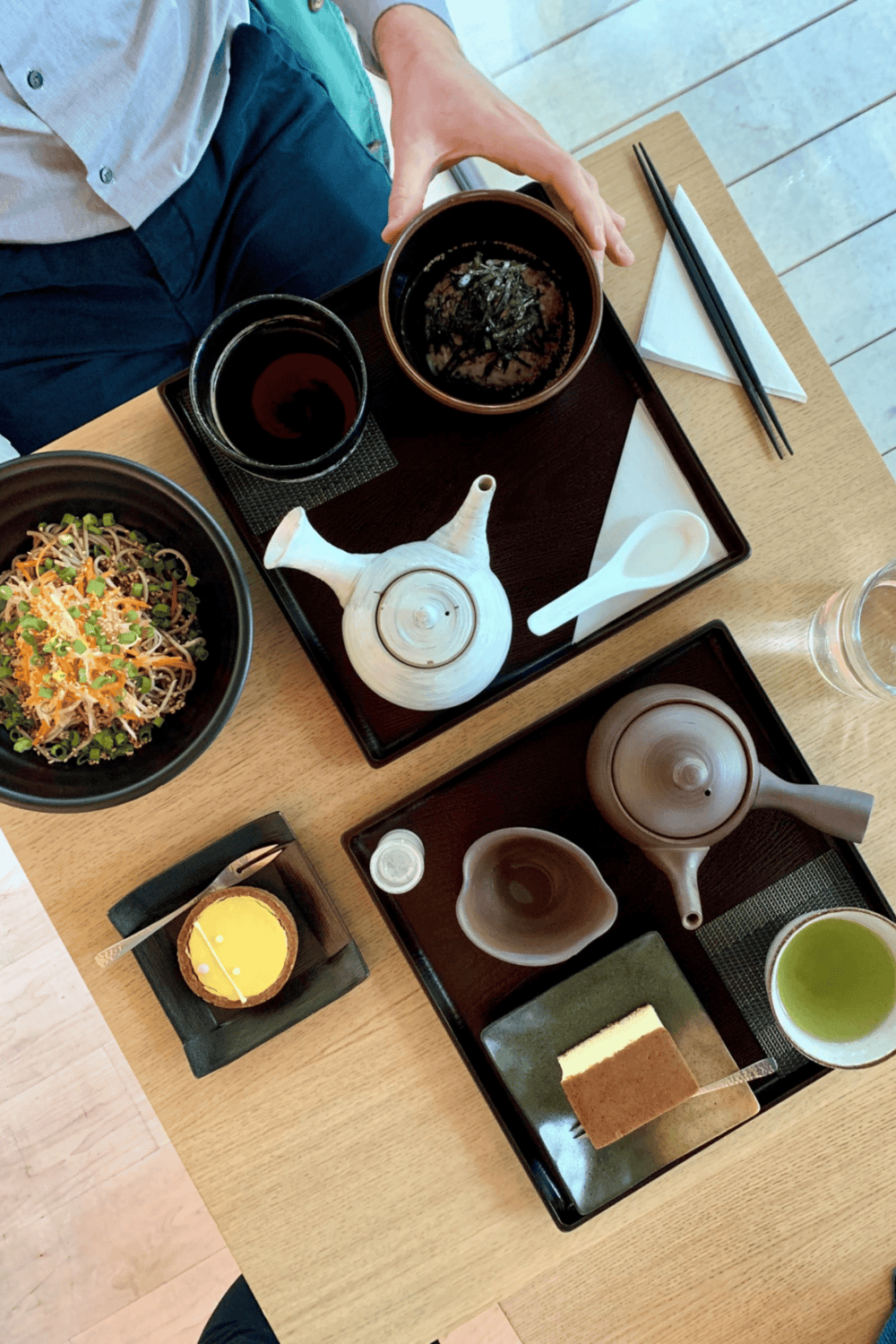 Steamed Japanese tea and dishes served with chopsticks at a restaurant table.