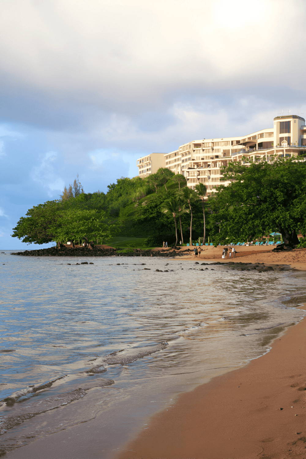 Modern beachfront resort with ocean view and lush greenery, ideal for a relaxation vacation.