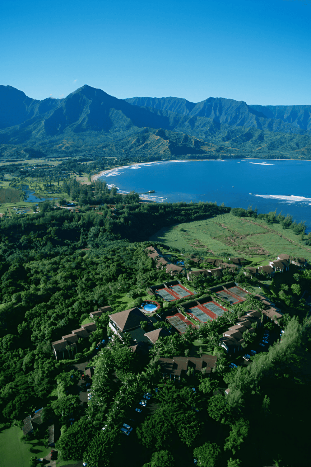 Secluded Hawaiian resort near scenic coastline with lush mountains and ocean views.
