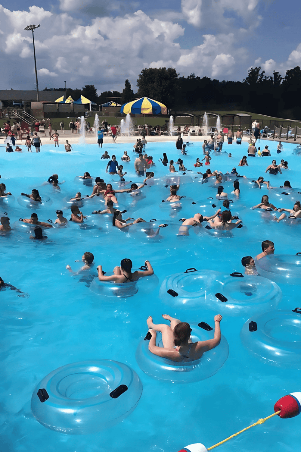 Vibrant water park with floating tubes, splash fountains, and families enjoying summertime fun.