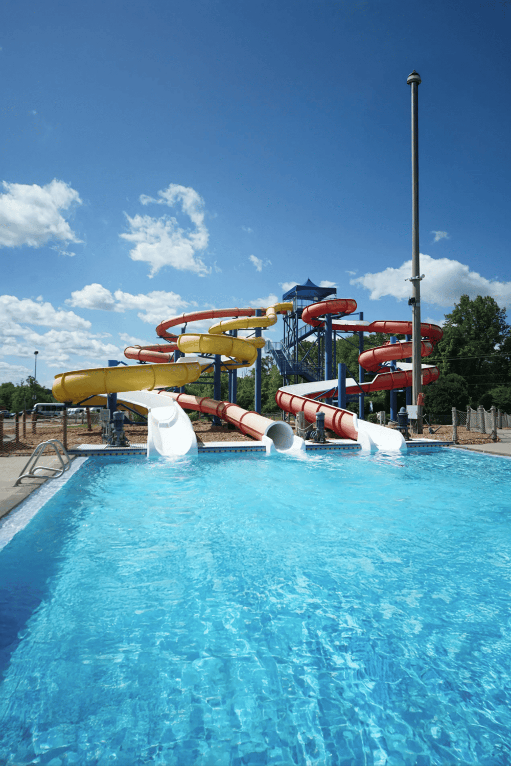 Water park water slides and pool, family fun outdoor activity, summer recreational entertainment.