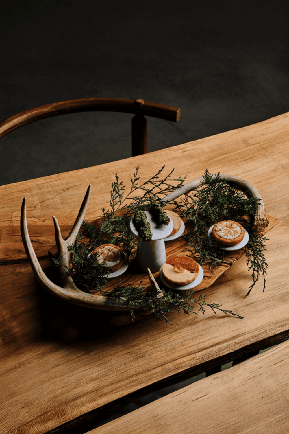 Antler decorative tray with herbs and cookies, rustic table setting, cozy home decor.