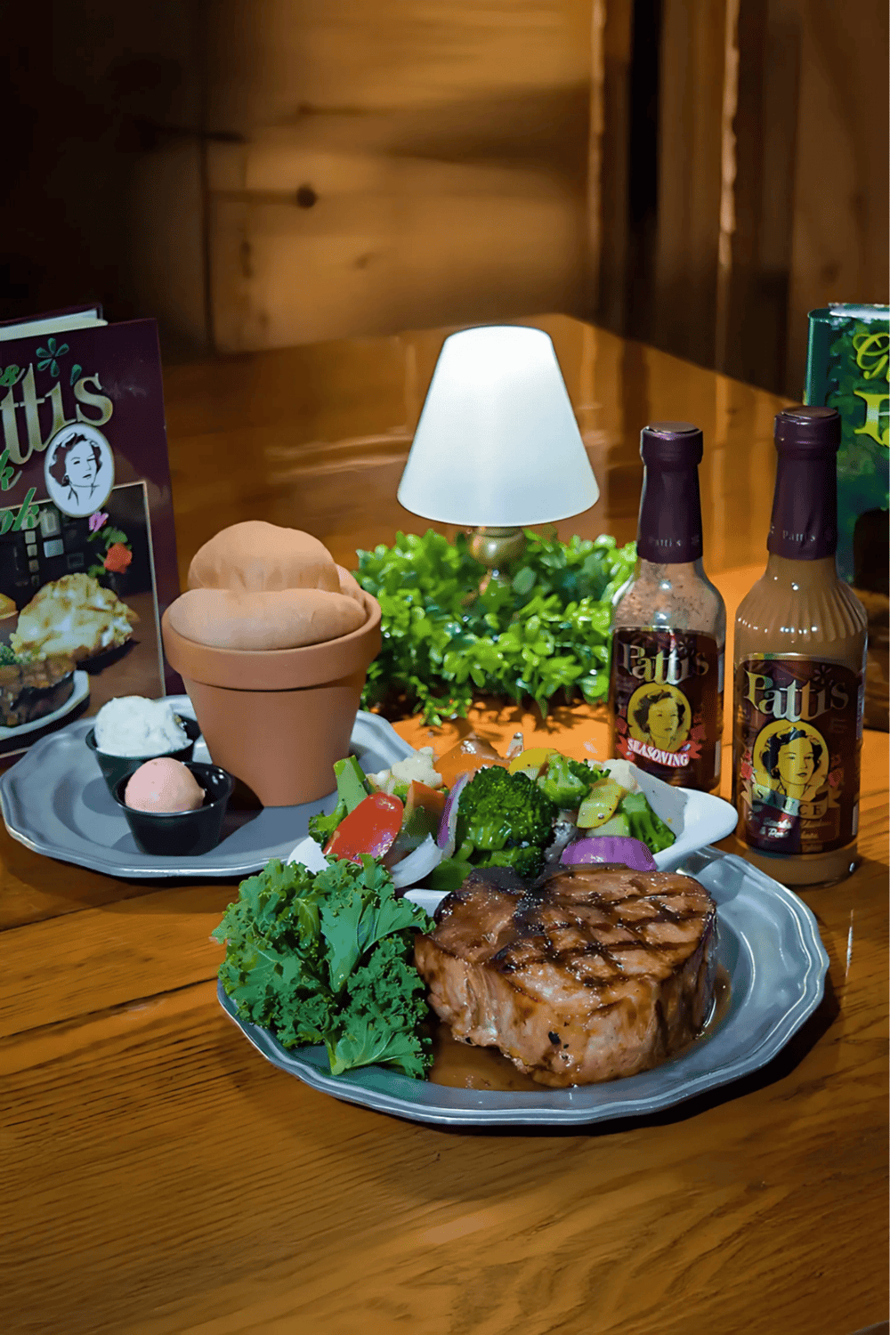 Delicious grilled steak with fresh salad and BBQ sauce, served with drinks at a cozy restaurant.