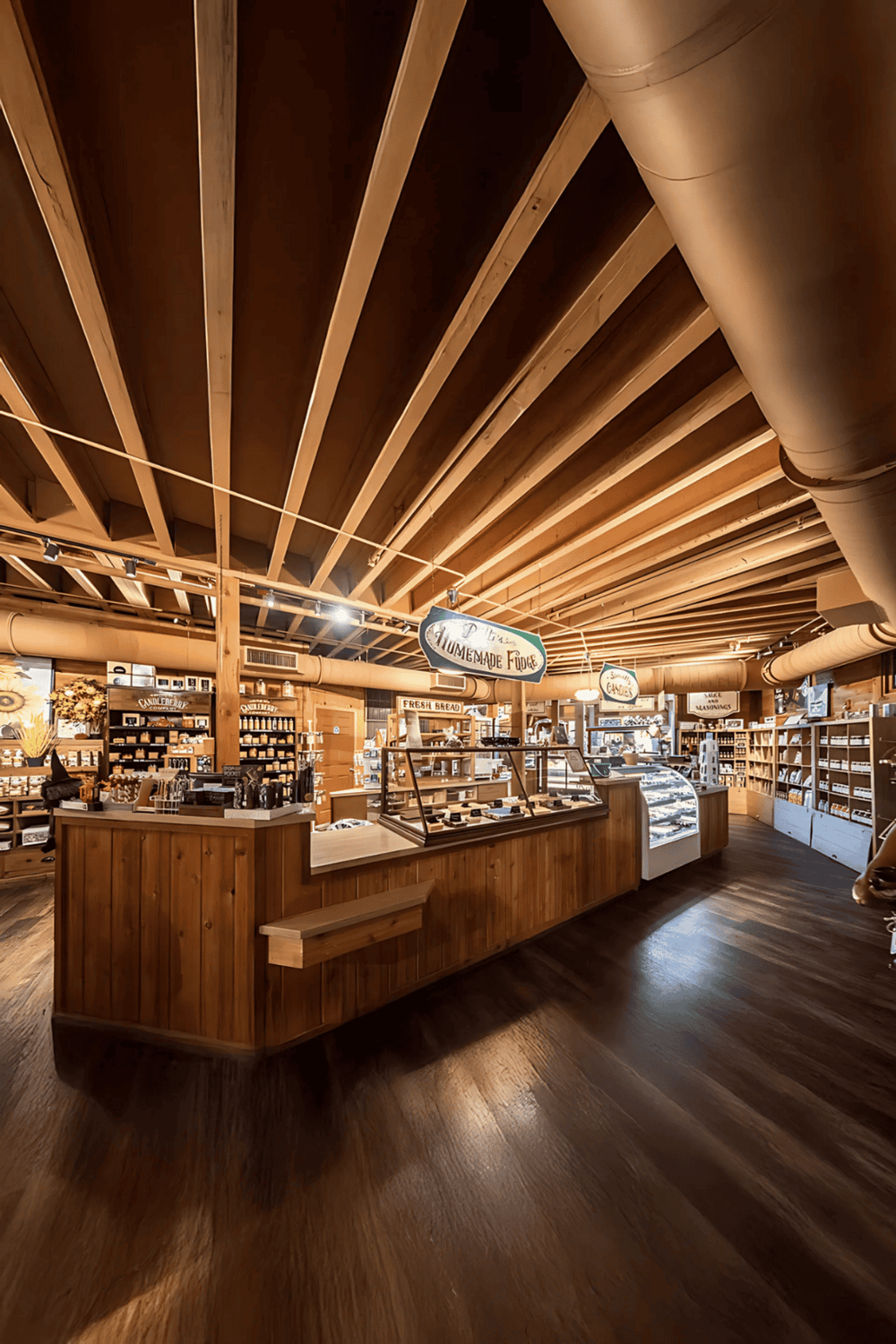 Warm wooden interior of a specialty food shop with shelves of baked goods and handmade fudge.