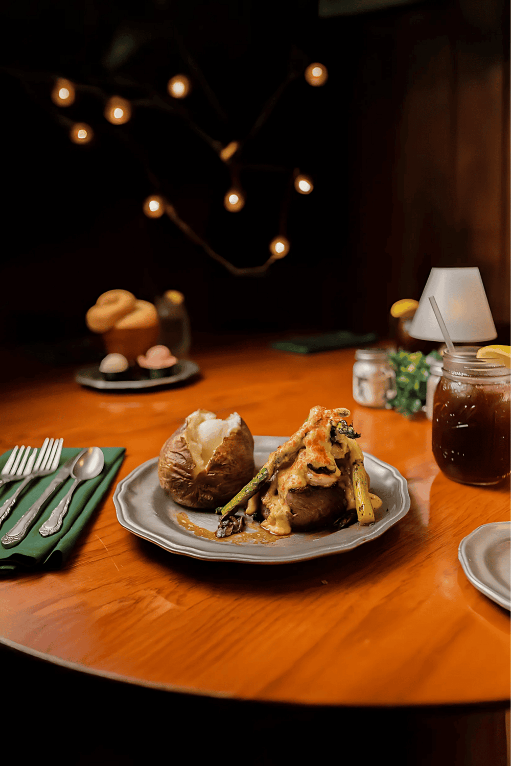 Crispy roasted vegetables with baked potato and iced coffee on a wooden table.