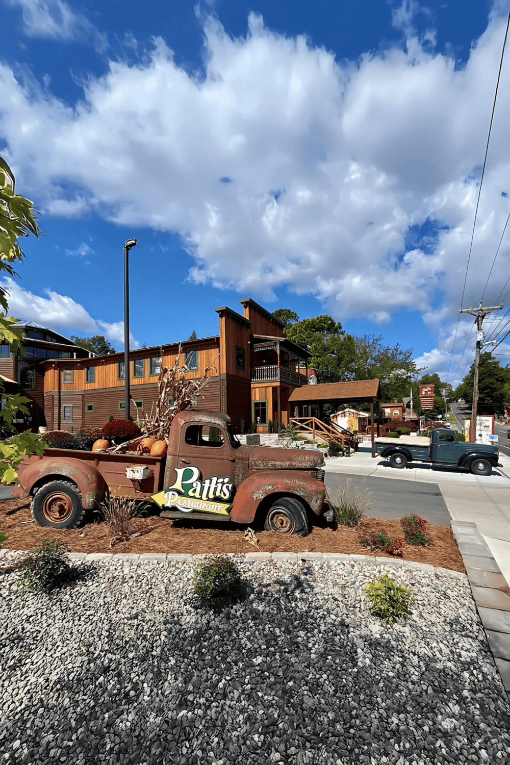 Rustic vintage truck with "Patti's Restaurant" sign outside a cozy restaurant building.