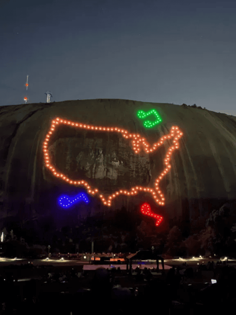 Colorful illuminated map of the United States displayed on a rock face at night for navigation and directional guidance.