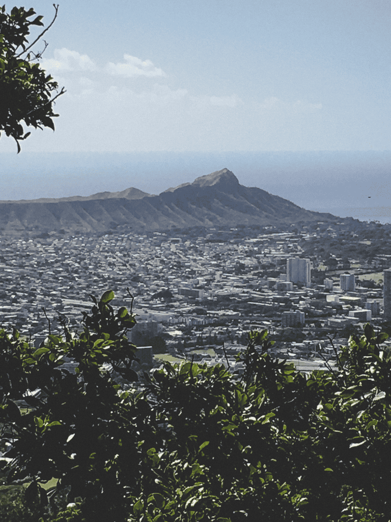 Vivid cityscape view of Honolulu with iconic Diamond Head crater in background, lush greenery in foreground, perfect for travel and adventure SEO.