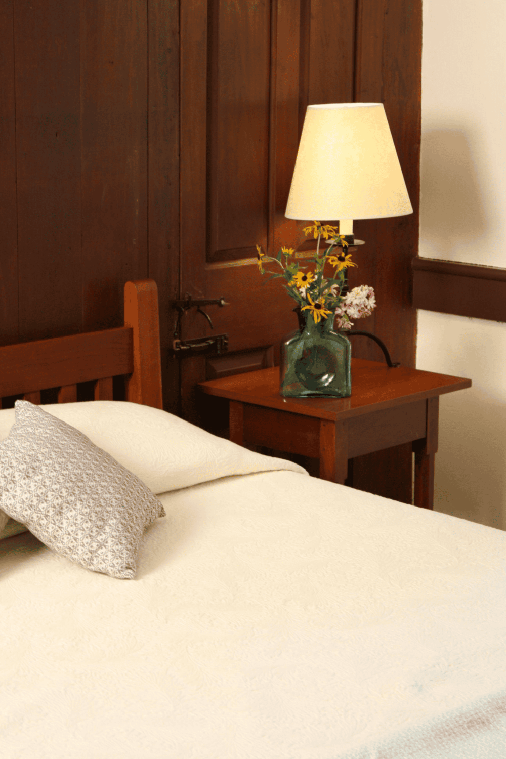 Comfortable bedroom with cozy bedding and decorative table lamp, perfect for relaxing stays.