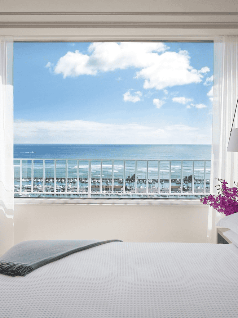 Stunning ocean view from a hotel room with balcony and sky scenery.