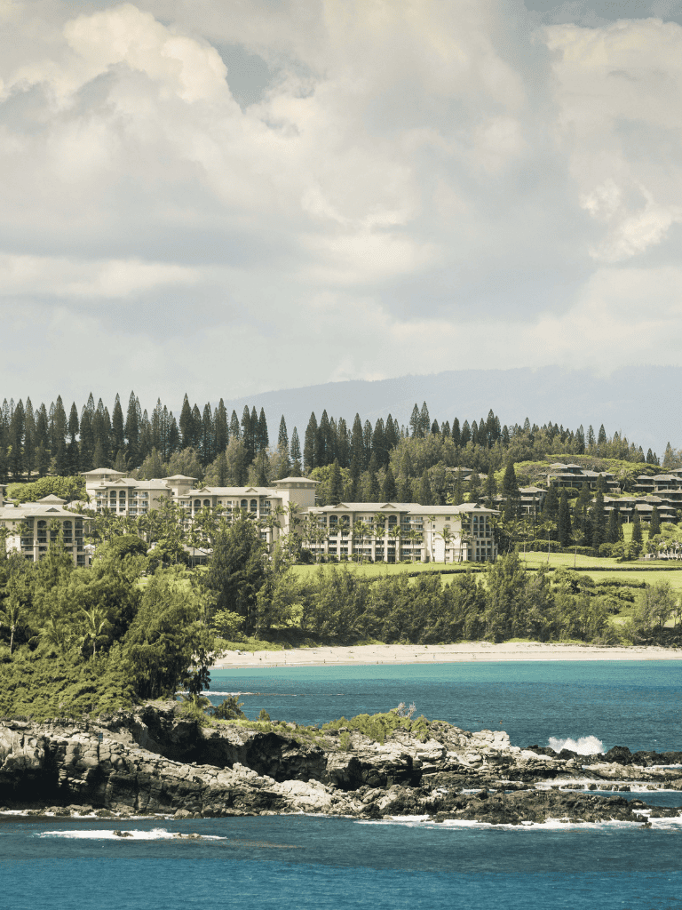 Luxury oceanfront resort in Hawaii with scenic views and lush greenery.