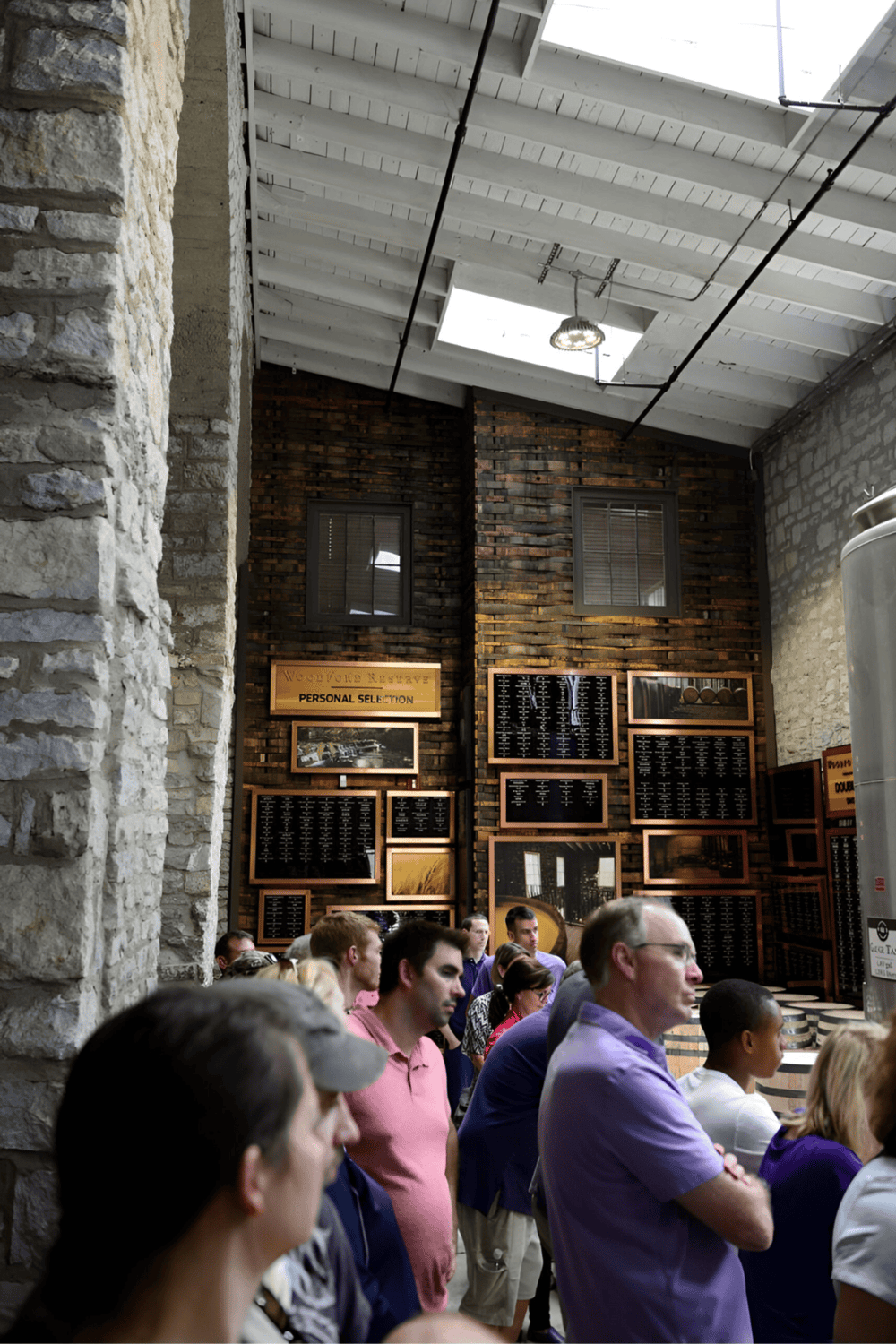 People waiting at a busy train station ticket counter with digital displays and rustic brick walls - QuestForDirections.