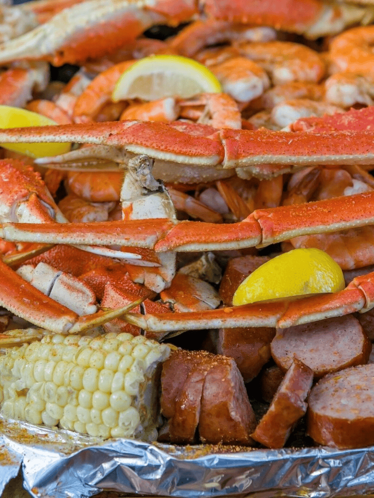 Succulent seafood boil with crab legs, shrimp, sausage, corn, and lemon wedges. Perfect for seafood lovers.
