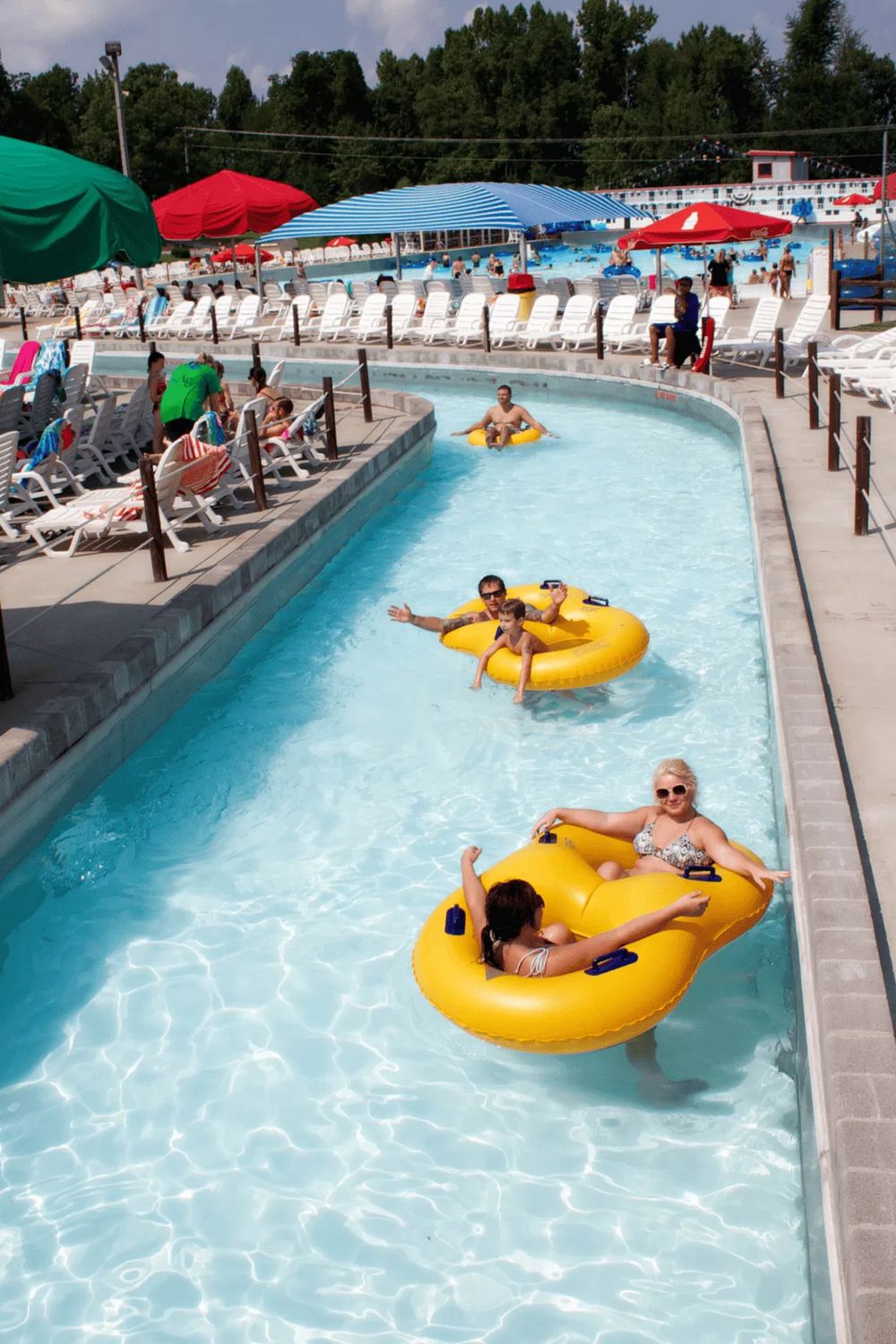 Bright outdoor water park with lazy river and lounge chairs, perfect for family fun and relaxation.