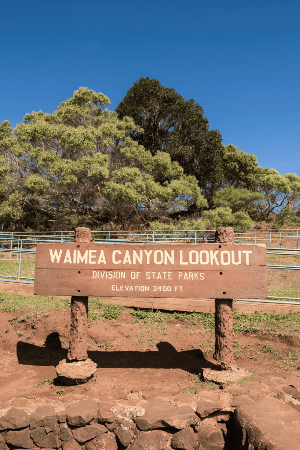 Serene Waimea Canyon Lookout at Hawaii's State Parks, showcasing lush greenery and clear blue skies.