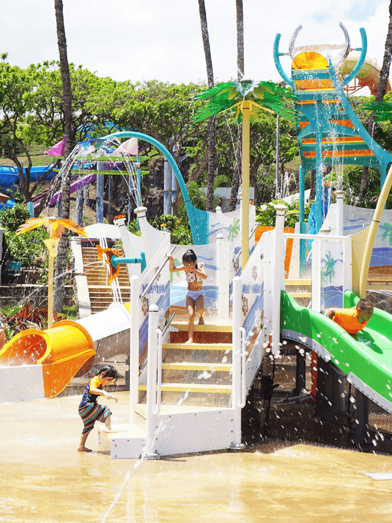 Kids playing on colorful water playground with slides and water features at Quest for Directions water park.