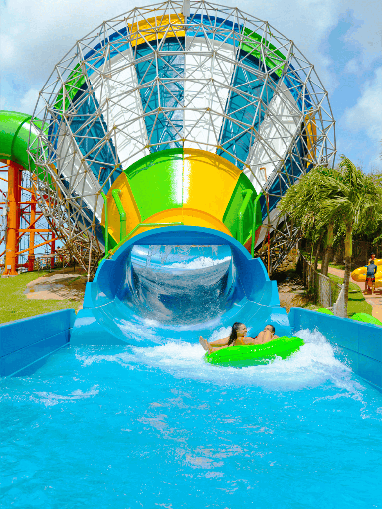 Vibrant water slide at Quest for Directions water park with riders enjoying the splash.