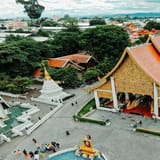 Colorful Thai temple with intricate architecture and lush surroundings in Thailand.