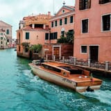 Venezia canal with boat, colorful buildings in Italy, popular travel destination, waterfront scenery.
