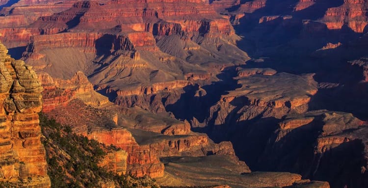 Vibrant Grand Canyon landscape showcasing layered red rock formations and deep valleys, iconic USA natural wonder.