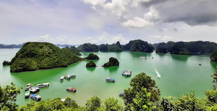Stunning view of lush islands and boats in Ha Long Bay, Vietnam, a top travel destination and scenic cruise location.