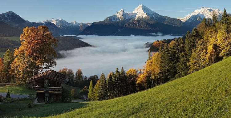 Breathtaking mountain landscape with snow-capped peaks and autumn foliage in Switzerland.