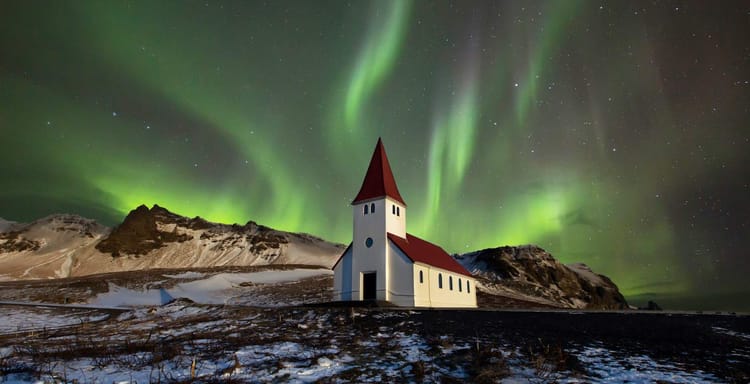 Aurora borealis over a small church in Iceland during winter night.