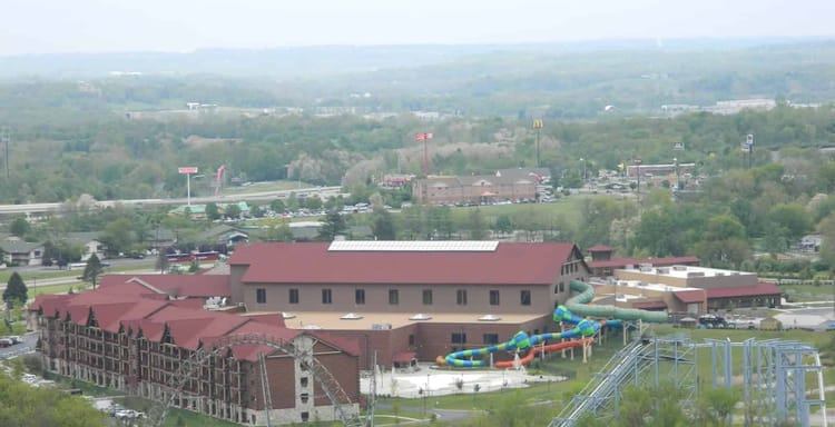 Rustic Ohio resort featuring a large lodge, water park slides, and nearby roller coaster.