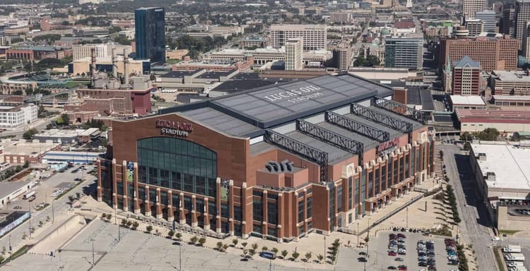 Aerial view of Lucas Oil Stadium and downtown Indianapolis skyline on a bright sunny day.