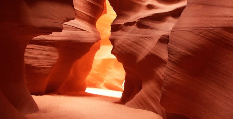 Stunning slot canyon with smooth, red sandstone walls illuminated by soft natural light.