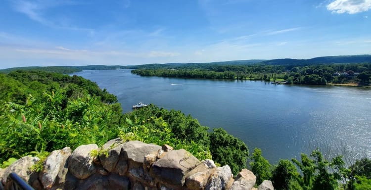 Breathtaking river view with lush greenery and clear blue sky, perfect for outdoor adventure and scenic exploration.