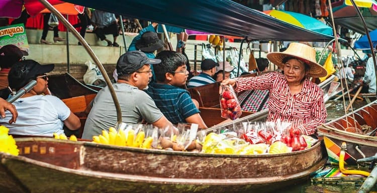 Vibrant floating market with fresh fruits and local vendors in Thailand.