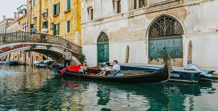 Venezian gondola ride along historic canals in Venice, Italy, with scenic architecture and picturesque views.