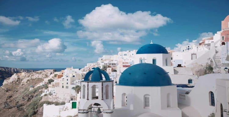 Vibrant Santorini village with iconic white buildings and blue domes, perfect for travel inspiration and scenic adventures.