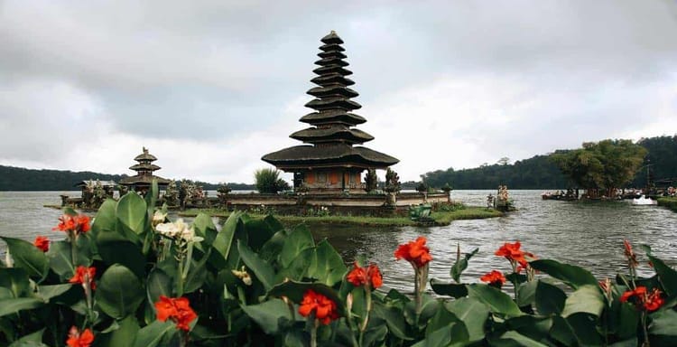 Ancient Hindu temple on Lake Beratan with lush greenery and scenic views in Bali, Indonesia.