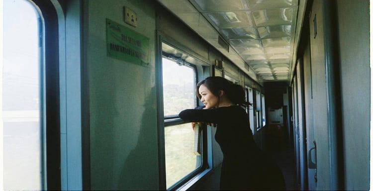 Young woman looking out train window, enjoying scenic landscape, travel, journey, adventure, transportation, exploration, mobility, scenic views, train travel.