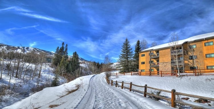 Snow-covered mountain road leading to Quest for Directions lodging in winter landscape.